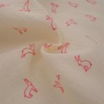 Tissu toile de coton à motif lapin rose fluo sur fond beige